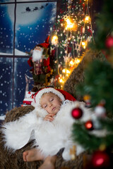 Beautiful toddler child, baby boy, sleeping on Christmas eve at home