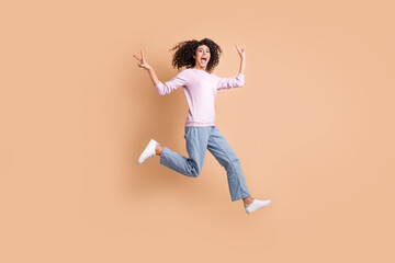 Fototapeta na wymiar Full body portrait of excited crazy person jump run open mouth show v-sign isolated on brown color background