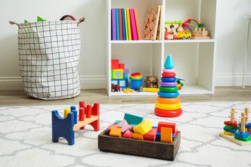 Colorful toys on white carpet in children room