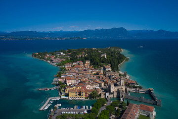 Sirmione, Lake Garda, Italy. Panoramic aerial view of the central city of Sirmione. In the background mountains, blue sky. In the summertime