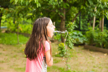Fountain of water from girl's mouth outdoor