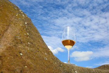 Glas mit Rosé Wein auf einem Stein