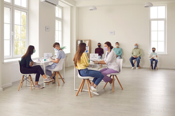 Diverse people talking to doctors before getting an antiviral injection at the hospital