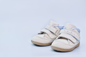 baby boy leather boots on blue background. comfortable orthopedic first footwear for kids. baby shower concept. first children outfit. 