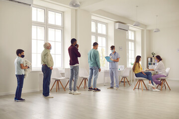 Diverse people standing in line at the hospital and waiting for their turn to get vaccine - obrazy, fototapety, plakaty