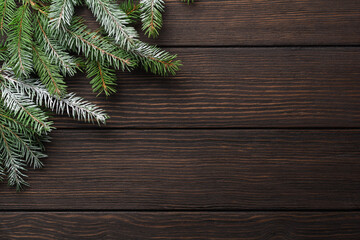 Christmas or New Year background with fir branches on a dark wooden background. Place for your text.