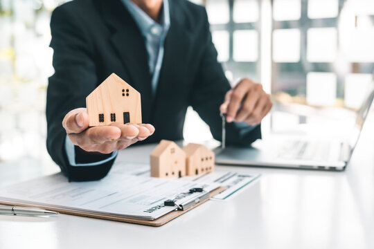Home insurance concept, home insurance agent can hold a small sample home model. In hand, it represents home protection for customers interested in insurance