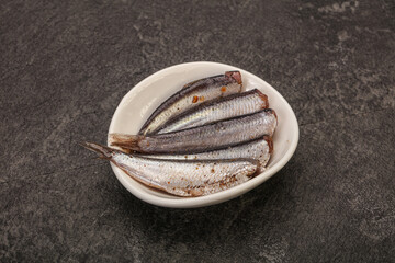 Anchovies in the bowl served basil leaves
