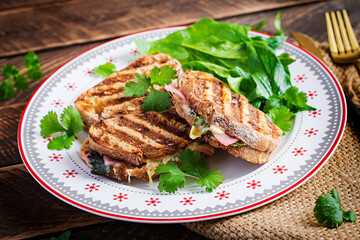 Grilled sandwich panini with ham, tomato, cheese and spinach. Delicious breakfast or snack. Copy space
