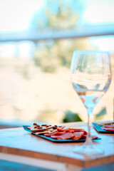 A glass of wine and a plate of cheese on the table.