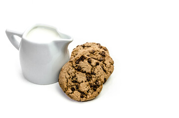 Close-up of homemade chocolate chip cookies with a jug of milk isolated on white background.