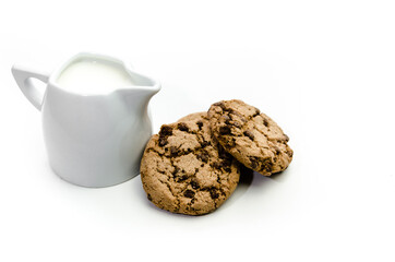 Close-up of homemade chocolate chip cookies with a jug of milk isolated on white background.