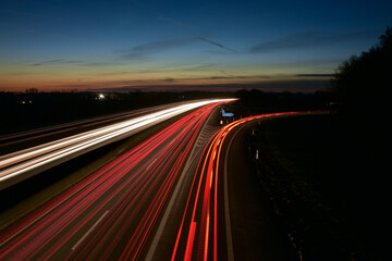 Autos auf der Autobahn bei Nacht. Langzeitbelichtung mit Straßenverkehr mit Scheinwerfern im Dunkelheit