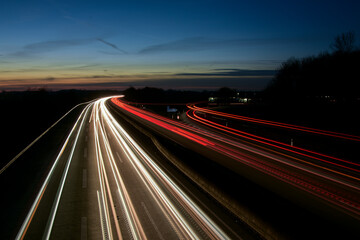 Autos auf der Autobahn bei Nacht. Langzeitbelichtung mit Straßenverkehr mit Scheinwerfern im...