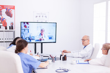 Medical physicians talking with medical specialist during teleconference. Medicine staff using internet during online meeting with expert doctor for expertise.