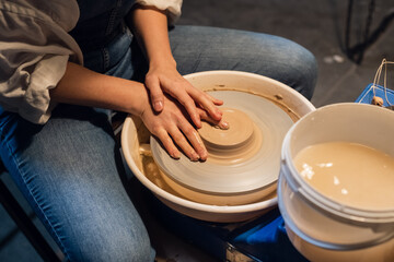 beautiful hands of a young potter's girl in the process of modeling a pot in the workshop.
