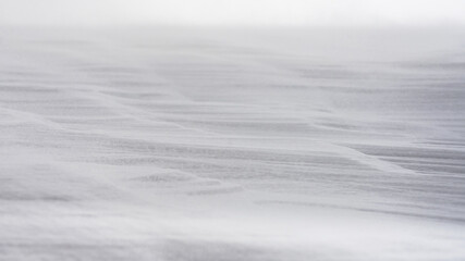 Textured snow surface during wind. Selective focus.