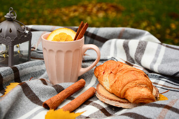 Autumn, winter composition. Cup of tea with orange, cinnamon, croissant, yellow leave  on gray background top view. Autumn, winter  card, composition, mood.  