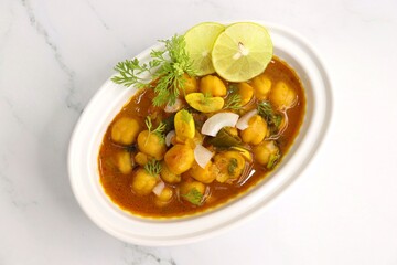 Indian food. Fresh chickpea masala, Chole masala curry, traditional north Indian dish. Popular Amritsari Chole bhature. Chana masala Garnished with lemon and onion. food photography. Copy space.