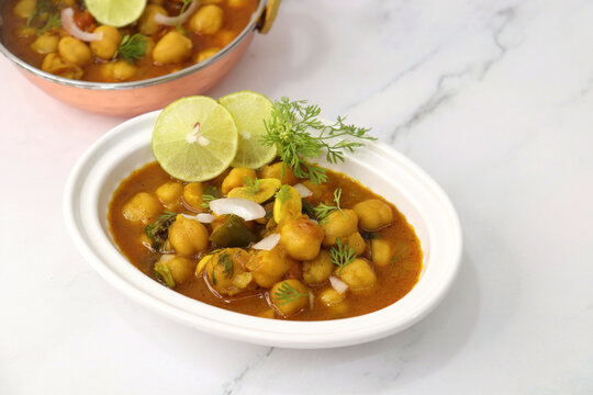 Indian food. Fresh chickpea masala, Chole masala curry, traditional north Indian dish. Popular Amritsari Chole bhature. Chana masala Garnished with lemon and onion. food photography. Copy space.
