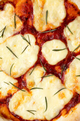 Homemade Margherita Pizza with Mozzarella and Rosemary, view from above. Flat lay, overhead, top view. Close-up.