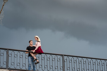 Beautiful loving each other couple is standing on the bridge