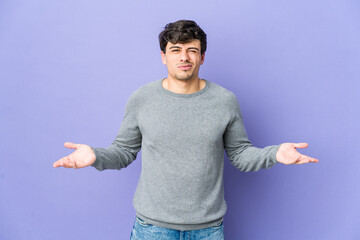 Young cool man doubting and shrugging shoulders in questioning gesture.
