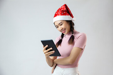 asia young woman in santa claus hat holding tablet on white background
