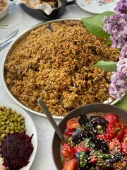 Pilaf with vegetables and lilac flowers, vertical