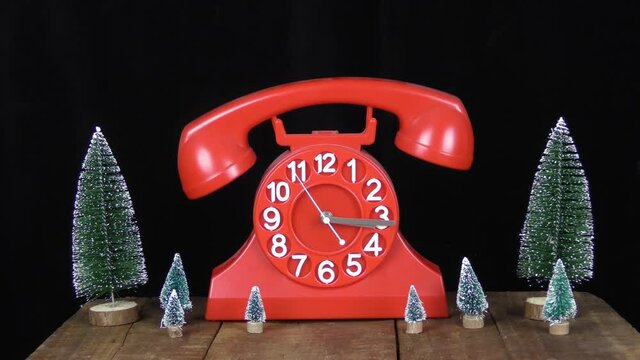 telefono orologio rosso con dondolio della cornetta ed alberi di natale