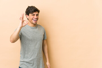 Young cool man cheerful and confident showing ok gesture.