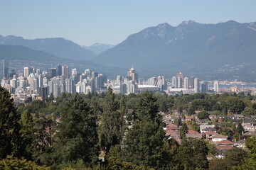 View of Vancouver downtown skyline with mountains and ocean during summer seen from Queen Elizabeth Park in Vancouver,  British Columbia, Canada