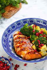 chicken salad with broccoli and ingredients on table. salad with meat, mango and pomegranate closeup