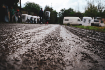 Shallow depth of field (selective focus) image with the mud on an unpaved road during a rainy summer day at a music festival.
