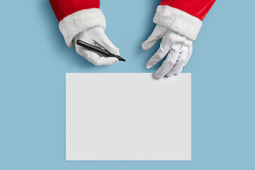 Top view of Santa Claus hands is writing to do list and goals in a blank paper sheet