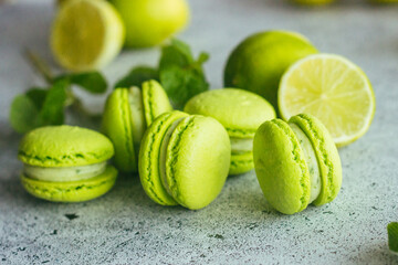 Macaroons. Green macaroons with lime and mint leaves. Delicious french desserts. Macaroons on the table