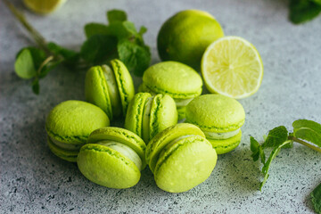 Macaroons. Green macaroons with lime and mint leaves. Delicious french desserts. Macaroons on the table