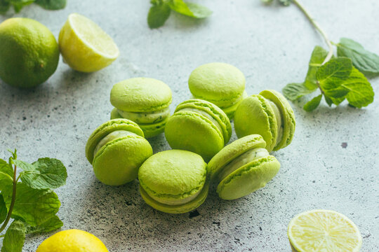 Macaroons. Green macaroons with lime and mint leaves. Delicious french desserts. Macaroons on the table