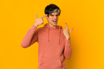 Young skinny hispanic man showing a disappointment gesture with forefinger.