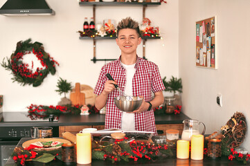 A young man in the kitchen preparing cookies for Christmas