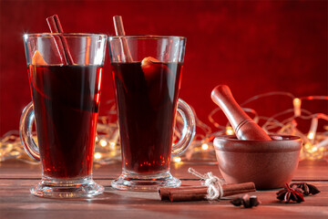Christmas traditional mulled wine with spices and illumination light.