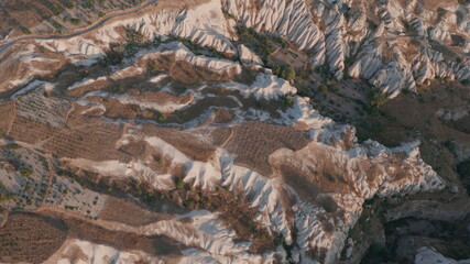 Aerial view from hot air balloon during Sunrise over the fairytale landscape hills of Kapadokya with morning light.