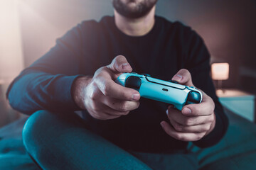 Close up of man, holding joy stick and playing video games on tv, sits at home on the bed © Jan Vašek