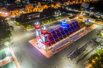 Aerial night view of meditating followers of the Cao Dai religion during Mid Autumn festival of Cao Dai people ( Caodaism) around temple in Tay Ninh city, Vietnam.