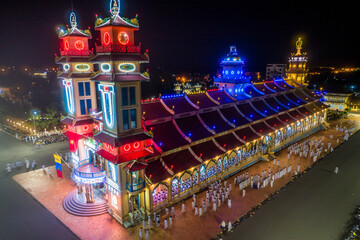 Aerial night view of meditating followers of the Cao Dai religion during Mid Autumn festival of Cao Dai people ( Caodaism) around temple in Tay Ninh city, Vietnam.