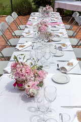 Wedding table decorated with bouquet of pink flowers and wine glasses.