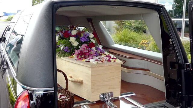 closeup shot of a funeral casket in a hearse or chapel or burial at cemetery