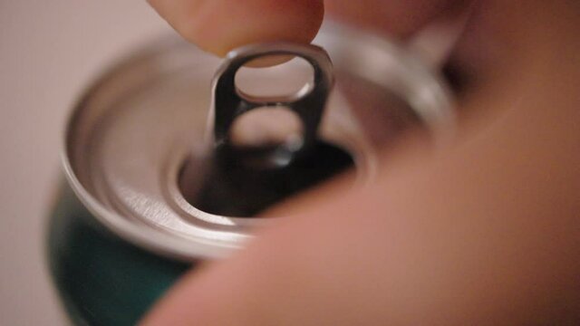 Close up of one finger opening an aluminum soda can.