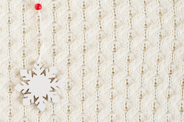 Snowflake on a white knitted surface.