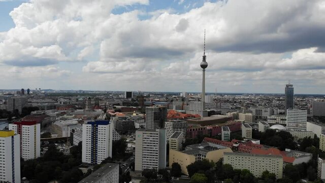 4k drone backward movement berlin tv tower with clouds and blue sky and high rise buildings friedrichshain lichtenberg east side